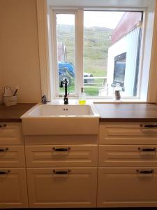cocina con fregadero y ventana en Ravencliff Lodge en Búðardalur