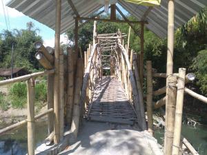 a wooden bridge over a body of water at Setro Kariyo Homestay in Bantul