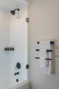 a bathroom with a shower and a sink and towels at Hu Hotel Memphis in Memphis +18 photos