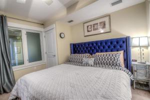 a bed with a blue headboard in a bedroom at Grand Panama Resort 2-202 By Aneliya in Panama City Beach