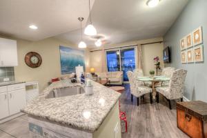 a kitchen and living room with a table and chairs at Grand Panama Resort 2-202 By Aneliya in Panama City Beach