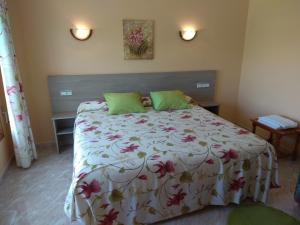 um quarto com uma cama grande e almofadas verdes em Hostal Brisa do mar em Portonovo