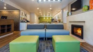 Best Western Grants Pass Inn في غرانتس باس: غرفة معيشة بها كرسيين ازرق واخضر وموقد