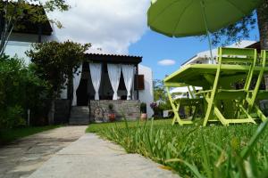a yellow chair and an umbrella in the grass at Halkidiki Trikorfo Luxury Maisonette in Gerakini