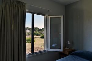 1 dormitorio con ventana y vistas a un campo en La Frontera en Mar de Ajó