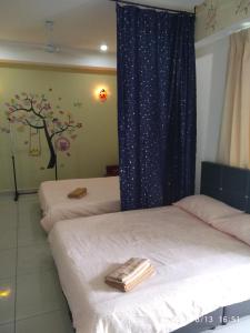 two beds in a room with a tree mural on the wall at 888@D'Perdana Sri Cemerlang in Kota Bharu