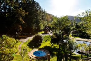 einen Garten mit einem Pool im Gras in der Unterkunft Chez Domaine Pousada Organica in Pedra Azul