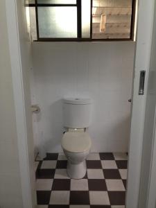 a white toilet sitting in a bathroom next to a window at The Metropolitan Hotel in Mackay