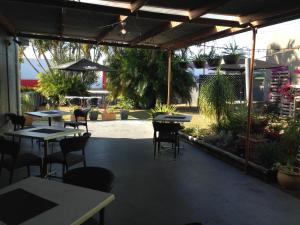 a patio area with tables, chairs, and tables with umbrellas at The Metropolitan Hotel in Mackay