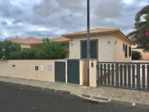 a house with green doors and a fence at casa de praia Nunes Village in Porto Santo