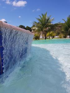 un tobogán de agua en una piscina de agua azul en Condomínio RCR Green Field Casas para Temporada, en Arraial d'Ajuda