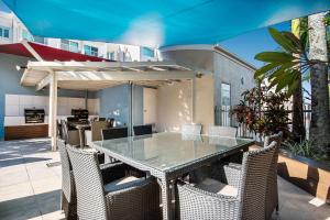 y un patio con mesa de comedor y sillas. en Sailport Mooloolaba Apartments, en Mooloolaba