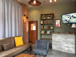 un soggiorno con un divano e una televisione di Villa Di Montagna at Khaoyai a Pak Chong