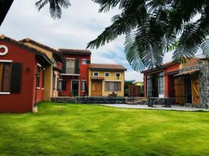 a group of houses in a yard with green grass at Villa Di Montagna at Khaoyai in Pak Chong