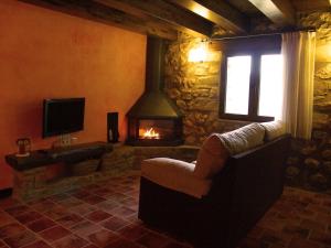 sala de estar con chimenea, sofá y TV en Font D'en Torres Solo Adultos, en Morella