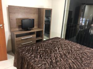 a bedroom with a bed and a tv on a dresser at Aldeia das Águas Park-Flat Quartier Luxo in Barra do Piraí