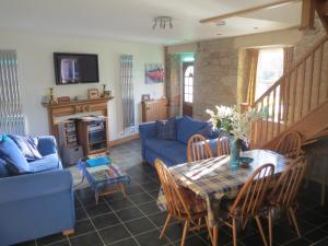 a living room with a table and a blue couch at Little Bethel Holiday Cottage in Coldstream