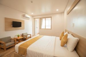 a hotel room with a bed and a tv at Summer Dream Hotel in Phú Quốc