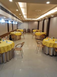 a room with tables and chairs with yellow table cloths at Hotel Amar Inn- Lajpat Nagar Central Market in New Delhi