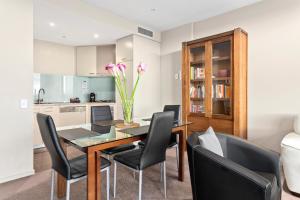 a dining room with a table and chairs and a kitchen at Docklands Private Collection - NEWQUAY in Melbourne