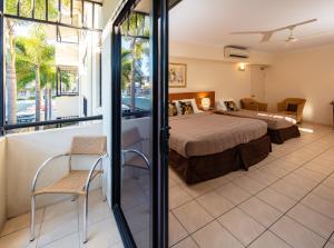a hotel room with a bed and a balcony at Cairns Queens Court in Cairns
