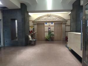 a hallway in a building with a door and a chair at Dengfeng Milan Business Hotel in Huwei