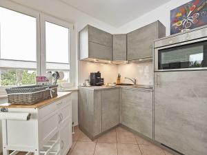 eine Küche mit Küchengeräten und Fenstern aus Edelstahl in der Unterkunft Wohnpark Stadt Hamburg in Binz - WG 54 in Binz