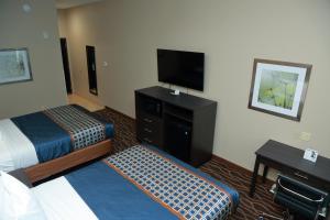 Prairieville にあるAmericas Best Value Inn & Suites-Prairievilleのベッド2台、薄型テレビが備わるホテルルームです。