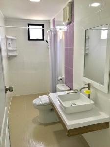 a bathroom with a sink and a toilet and a mirror at Mae On Village Resort in Roi Et