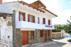 una casa bianca con finestre rosse e un balcone di Kaldi's Traditional House a Kastamonítsa