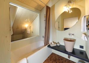Weissbad Lodge في فيسباد: حمام مع حوض ومرآة