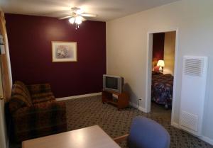 a living room with a tv and a bedroom at Boundary Motel in Osoyoos
