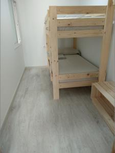 サン・カルラス・デ・ラ・ラーピタにあるApartaments Can Fabulの二段ベッドが備わるウッドフロアの客室です。