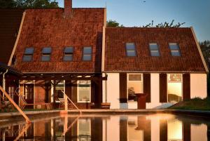 a building with a reflection in a pool of water at De Woeste Wieven op Erve Bonkert in Diepenheim