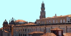 a tall building with a clock on the top of it at Grande Oceano Guest House in Porto