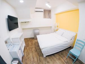 mały pokój z łóżkiem i telewizorem w obiekcie 放個Jia w mieście Taidong