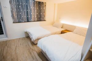 mały pokój z dwoma łóżkami i oknem w obiekcie 放個Jia w mieście Taidong