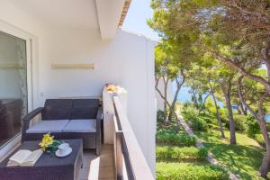 balkon z ławką i stołem z kwiatami w obiekcie Apartamento Ferrera Park 623 w mieście Cala Ferrera