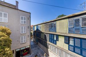 an alley between two buildings with blue shutters at Ema 2BR apt. in old town centre in Zadar