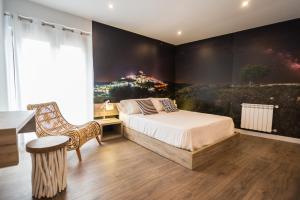 1 dormitorio con 1 cama y una pintura en la pared en Sant Joan, en Morella