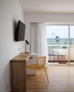 a room with a desk with a television and a chair at Hotel Foners in Playa de Palma