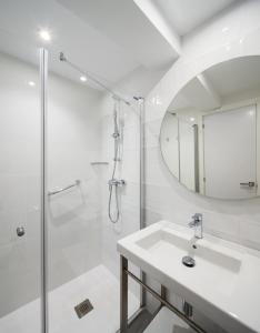 a white bathroom with a sink and a shower at Hotel Foners in Playa de Palma