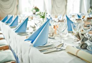 a long table with blue napkins and silverware on it at Pałac Łomnica - Karkonosze / Riesengebirge in Jelenia Góra