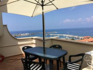 a blue table and chairs on a balcony with an umbrella at Villa Angelica in Vibo Valentia Marina