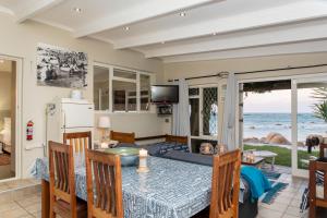 a living room with a table and a view of the ocean at Piccolo Villa in St. Helena Bay