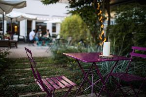 einen lila Tisch und zwei Stühle mit einer Kerze drauf in der Unterkunft Hotel Casali in Cesena