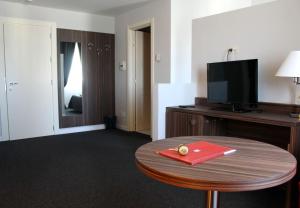 una habitación de hotel con una mesa con una carpeta roja en La Fonte dell'Astore, en Castelpetroso