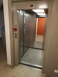 an elevator in a building with a glass door at Airport Orio Studio in Bergamo