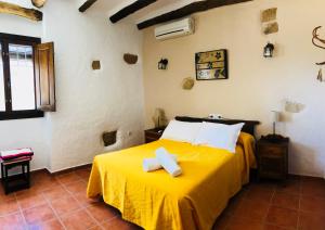 a bedroom with a yellow bed with towels on it at Cortijo El Horcajillo in Villanueva de Algaidas +43 photos