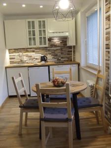uma cozinha com uma mesa com uma taça de fruta em Centro apartamentai em Druskininkai